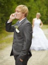 Groom has turned away from bride - speaks on phone Royalty Free Stock Photo