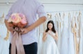 Groom hiding flower behind back in order to surprise bride,Woman positive emotion and face astonished