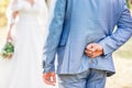 Groom hiding flower behind back in order to surprised bride on the wedding day,Woman positive emotion and face astonished happy Royalty Free Stock Photo