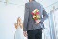 Groom hiding flower behind back in order to surprised bride on the wedding day,Woman positive emotion and face astonished happy an