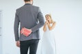 Groom hiding red gift box behind back in order to surprise bride on the wedding day,Woman positive emotion and face astonished hap