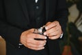 The groom on his wedding day holds two wedding rings in his hand in a hotel room. The man is wearing a white shirt and Royalty Free Stock Photo