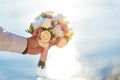 Groom holding bouquet of flowers on the beach. Sea background Royalty Free Stock Photo