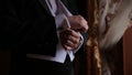 Groom is holding hands on the tie, wedding suit. close up of a hand man how wears white shirt and cufflink. Business man
