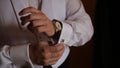 Groom is holding hands on the tie, wedding suit. close up of a hand man how wears white shirt and cufflink. Business man