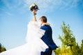 Groom holding his bride with bouquet in hands Royalty Free Stock Photo