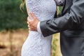 Groom holding his passionate newlywed bride, outdoor luxury wedding