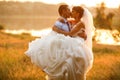 Groom is holding and kissing his bride on the background evenin Royalty Free Stock Photo