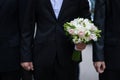 Groom holding a wedding bouquet Royalty Free Stock Photo