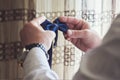 the groom holds a bow tie in his hands. the groom preparations in the morning. close-up of hands