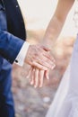 Groom holds bride hand in white dress