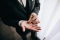 The groom holds in his hands golden wedding rings