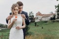 Groom  hugging beautiful gorgeous bride with poppy flower. happy sensual wedding couple embracing in love, at old castle. happy Royalty Free Stock Photo