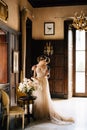 Groom hugs bride from behind near the table with a bouquet of roses in an old villa. Lake Como Royalty Free Stock Photo
