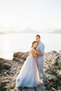 Groom hugs bride on the stone coast by the sea Royalty Free Stock Photo