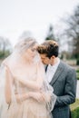 Groom hugs bride in a veil from behind and kisses her on the shoulder. Lake Como, Italy Royalty Free Stock Photo