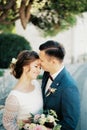 Groom hugs bride by the waist and kisses her forehead. Portrait Royalty Free Stock Photo