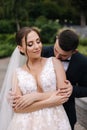 Groom hugs his bride from behind and kiss. Happy newlyweds Royalty Free Stock Photo