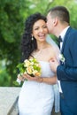 Groom kiss happy bride with bouquet. Woman and man smile on wedding day. Wedding couple in love. Newlywed couple on Royalty Free Stock Photo