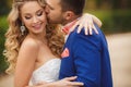 The groom kisses the bride in a green Park in the summer. Royalty Free Stock Photo