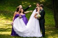 Groom kisses a bride while his friends grimaces behind him Royalty Free Stock Photo