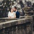 Groom kisses a bride hugging her from behind on the old balcony Royalty Free Stock Photo