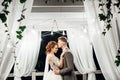 Groom kisses bride`s cheek tender hugging her in the garden Royalty Free Stock Photo