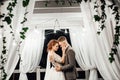 Groom kisses bride`s cheek tender hugging her in the garden Royalty Free Stock Photo