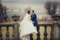 Groom kisses a bride sitting with her on the balcony with a great landscape behind them Royalty Free Stock Photo