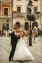 Groom kisses a charming bride while wind blows her dress along t