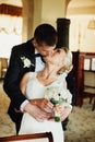 Groom kisses a smilung bride hugging her from behind Royalty Free Stock Photo