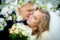 The groom is kissing the bride in branches of the blossoming che