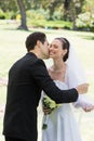 Groom kissing bride in garden