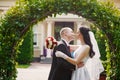 Groom kissing his bride on wedding day near arch Royalty Free Stock Photo