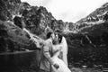 The groom kissing his young bride, on the shore of the lake Morskie Oko. Poland. Black and white photo