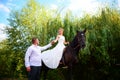 The groom leads the horse by the bridle. Bride sits in the saddl Royalty Free Stock Photo