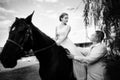 The groom leads the horse by the bridle. Bride sits in the saddl Royalty Free Stock Photo