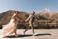 Groom in modern suit and bride in charming pink dress pose on the terasse with great mountain view in Georgia Royalty Free Stock Photo