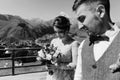 Groom in modern suit and bride in charming pink dress pose on the terasse with great mountain view in Georgia Royalty Free Stock Photo