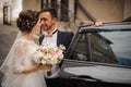 Groom opens the door of the wedding car, intending to kiss the bride Royalty Free Stock Photo