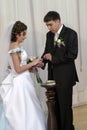 Groom placing ring on brides hand