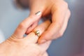 Groom put engagement ring on his bride finger. Jewellery diamond ring in husband to be hands. He put wedding ring on her finger. Royalty Free Stock Photo