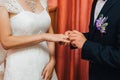 Groom puts a gold wedding ring on the bride`s finger Royalty Free Stock Photo