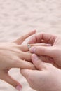 Groom puts ring on Bride - Beach Wedding