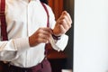A groom putting on cuff-links as he gets dressed in formal wear. A man straightens cufflinks. Groom`s suit Royalty Free Stock Photo