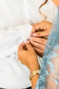 A groom putting on cuff-links as he gets dressed in his wedding day. Groom`s suit Royalty Free Stock Photo