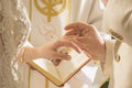 Groom putting ring on bride during religious ceremony