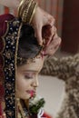 Groom putting Sindoor on Bride's forehead in Indian Hindu wedding.