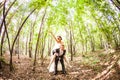 Groom running away with bride on his back in park Royalty Free Stock Photo