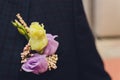 Groom`s boutonniere on a jacket of dark blue color. The wedding boutonniere consists of a pink rose, a small dianthus Royalty Free Stock Photo